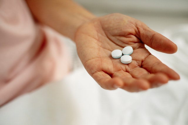 A person holding pills.